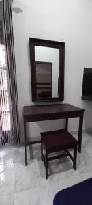 einen Tisch mit einem Spiegel und einem Stuhl im Zimmer in der Unterkunft Airport Pearl Garden Transit Hotel in Arambe