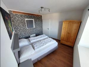 een slaapkamer met een bakstenen muur en een bed bij Ruime en gezellige vakantiewoning Brilon Alme Sauerland met terras en uitzicht in Brilon
