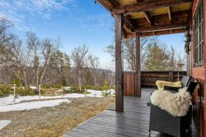 a porch of a cabin with a bench on a deck at Koslig hytte ved Grimsdalen in Dovre