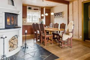 a dining room with a table and chairs and a fireplace at Koslig hytte ved Grimsdalen in Dovre