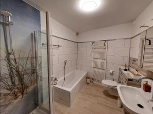 een badkamer met een bad, een toilet en een wastafel bij Ruime en gezellige vakantiewoning Brilon Alme Sauerland met terras en uitzicht in Brilon