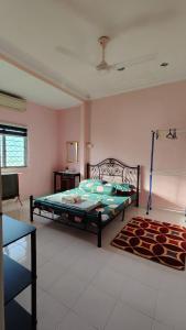 1 dormitorio con cama y alfombra en Yamad Homestay Langkawi, en Kuah