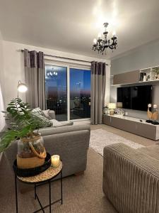 a living room with a couch and a large window at Manchester City football Stadium View in Manchester