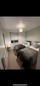 a bedroom with two beds and a window at Manchester City football Stadium View in Manchester