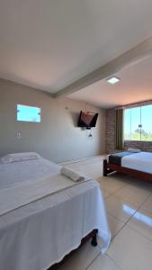 ein Schlafzimmer mit einem großen Bett und einem Flachbild-TV in der Unterkunft Canto da Duna Hotel in Barreirinhas