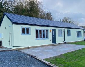 a small white house with a blue door at Shepherd's Cottage in Totland