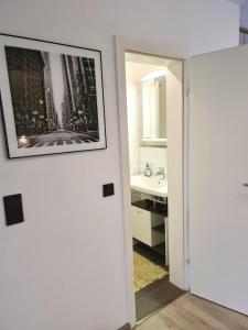 ein Badezimmer mit einem Waschbecken und einem Bild an der Wand in der Unterkunft Ruhiges & gemütliches Apartment im Herzen von Hüde 300 m entfernt vom Dümmer See in Hüde + 12 Fotos