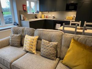 a couch with pillows sitting in a kitchen at Shepherd's Cottage in Totland