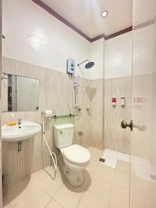 uma casa de banho com um chuveiro, um WC e um lavatório. em Endless Summer Hotel Baler em Baler