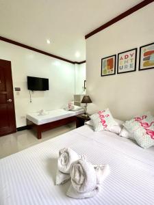um quarto de hotel com duas camas com toalhas em Endless Summer Hotel Baler em Baler