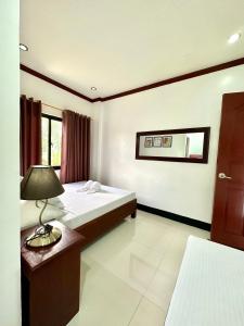 um quarto com duas camas e um candeeiro sobre uma mesa em Endless Summer Hotel Baler em Baler