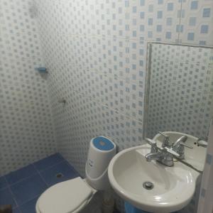 uma casa de banho com um WC branco e um lavatório. em RED HOUSE 47 em Cartagena de Indias