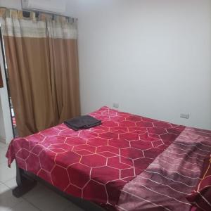 um edredão roxo numa cama num quarto em RED HOUSE 47 em Cartagena de Indias