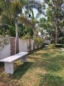 a bench in a park with a palm tree at Shamrock Inn in Cochin