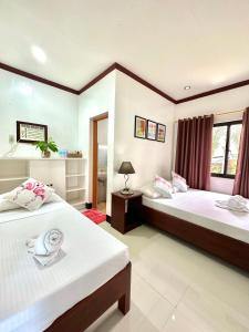a bedroom with two beds and a window at Endless Summer Hotel Baler in Baler