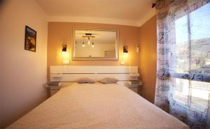 1 dormitorio con 1 cama grande y espejo en le verger des naiades en Le Lavandou