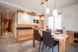 Il comprend une cuisine et une salle à manger avec une table et des chaises en bois. dans l'établissement Ca' Leonardi - Valle di Ledro, à Ledro