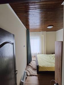 a bedroom with a bed and a wooden ceiling at ALEXANDER Ski Lake View in Beliş