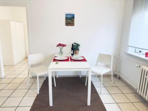 a white table and chairs in a room at Möbliert-Ruhige Lage- W-LAN -Netflix-Herne in Herne