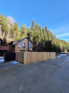 a wooden fence in front of a house at ALEXANDER Ski Lake View in Beliş