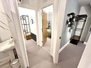 a bathroom with a hallway with a sink and a mirror at 6 Guests - 3 Bed House in Chester-le-Street in Chester-le-Street +19 photos