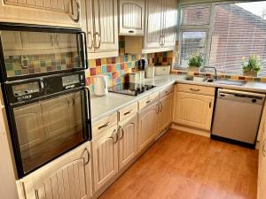 a kitchen with white cabinets and a black refrigerator at 6 Guests - 3 Bed House in Chester-le-Street in Chester-le-Street