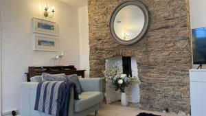a living room with a stone fireplace with a mirror at Dartmouth Town Centre 2 bedroom stylish apartment is perfect for families and couples with a happy & homely feel being only 30 meters from the sea but set back & quiet with everything on the doorstep a gorgeous place to explore the Devon beaches 5 star FB in Dartmouth