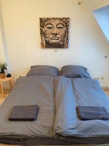 1 cama con 2 almohadas y una pintura en la pared en Stilvolle helle Wohnung im Zentrum, en Osnabrück