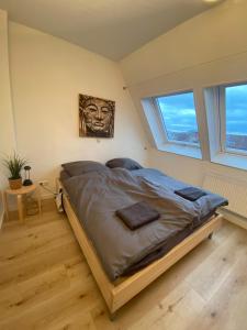 ein großes Bett in einem Zimmer mit zwei Fenstern in der Unterkunft Stilvolle helle Wohnung im Zentrum in Osnabrück