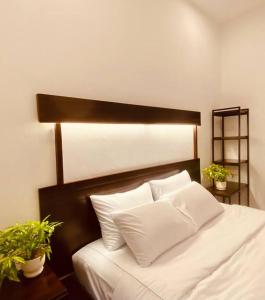 1 cama con sábanas blancas y almohadas en una habitación en Fa's House Hue, en Thôn Kim Long (1)