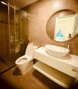 W łazience znajduje się toaleta, umywalka i lustro. w obiekcie Fa's House Hue w mieście Thôn Kim Long (1)