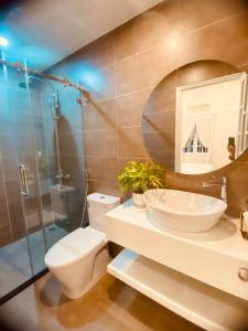 La salle de bains est pourvue de toilettes, d'un lavabo et d'un miroir. dans l'établissement Fa's House Hue, à Thôn Kim Long (1)