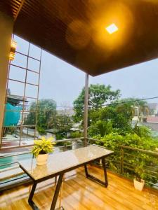 d'une terrasse avec une table et des plantes sur un balcon. dans l'établissement Fa's House Hue, à Thôn Kim Long (1)