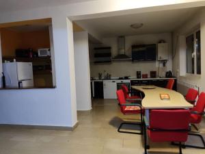 eine Küche mit roten Stühlen und einem Tisch im Zimmer in der Unterkunft Vila spatioasa 7 camere la lacul BUftea in Buftea