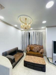 a living room with a couch and a chandelier at WisTree Luxury Service Apartment-Bkc in Mumbai