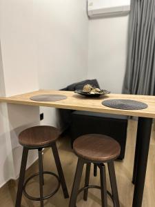 un mostrador de madera con dos taburetes en una mesa en Olive-Luxury apartment in agrinio en Agrinion