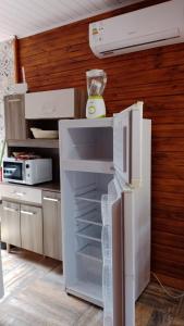 um frigorífico branco com a porta aberta numa cozinha em Cabañas azules em Punta Del Diablo