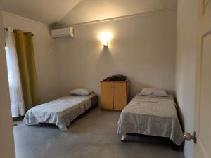 ein Schlafzimmer mit 2 Betten und einer Kommode darin in der Unterkunft Naturo Villa 16 in Poste Lafayette
