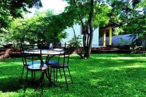 a table and chairs sitting in the grass at Twin Blocks Nature Resort in Anuradhapura