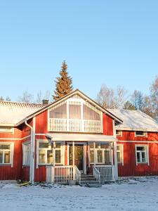 ein rotes Haus mit Schnee auf dem Boden in der Unterkunft Huoneisto Toloppa in Ranua