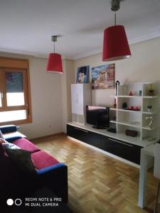 a living room with a couch and a desk with a tv at Ceraca in Pola de Somiedo