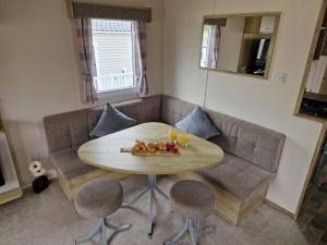 a living room with a table and a couch at Weymouth Bay Haven, Preston Road in Weymouth