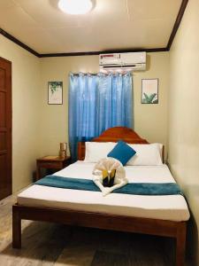 a bedroom with a bed with a bow on it at Dreamcatcher Hostel in Moalboal