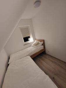 2 łóżka w małym pokoju z oknem w obiekcie Sosnowe Wzgórze - Wypoczynek w Zagórzu Śląskim 1 w Zagórzu Śląskim