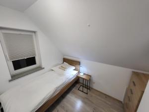 ein kleines Schlafzimmer mit einem Bett und einem Fenster in der Unterkunft Sosnowe Wzgórze - Wypoczynek w Zagórzu Śląskim 1 in Kynau