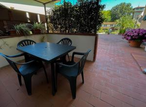 een zwarte tafel en stoelen op een bakstenen patio bij La Terrazza in Pietrasanta