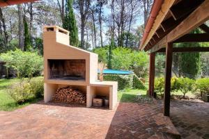a brick patio with a fireplace in a backyard at Casa Acuario - großes Haus mit besonderem Flair in Punta del Este