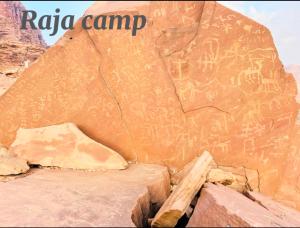 a rock wall with some writings on it at Raja camp in Wadi Rum
