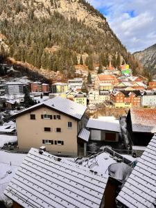 a town with snow covered roofs and a mountain at AFA in Göschenen