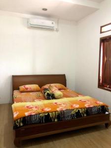 un letto in una stanza con media di Villa Sari Leueut Suramadu Majalengka 